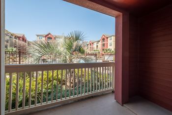 a balcony with a view of a palm tree